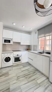 - une cuisine blanche avec des placards blancs et un lave-vaisselle dans l'établissement Fabuloso apartamento a 50m de playa centrico, à Torre del Mar