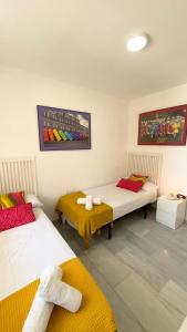 une chambre avec deux lits et une table dans l'établissement Fabuloso apartamento a 50m de playa centrico, à Torre del Mar