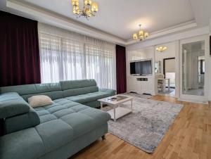 a living room with a blue couch and a television at Vila Premium Iasi in Iaşi