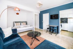 a living room with a blue couch and a table at Studio in City Centre Lux in Luxembourg