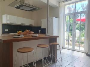 a kitchen with a counter with stools in it at La maison des Vendangeurs 6 in Olonzac