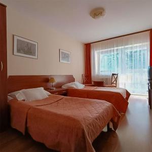 a hotel room with two beds and a window at Ośrodek Wypoczynkowy "Przy Lesie" in Karpacz