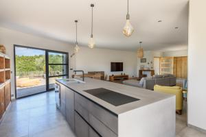 Una cocina con encimera y una sala de estar. en La colle aux sources, en Esparron-de-Verdon