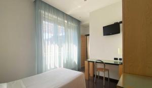a bedroom with a bed and a desk and a window at Luxury Rooms Padova Station in Padova