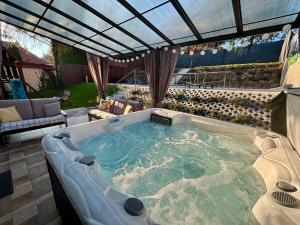 a large hot tub in a yard with a patio at Panorámaház Bükkszék in Bükkszék