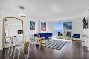 マイアミにあるAmazing apartment in the Heart of Brickellのリビングルーム(ガラステーブル、青いソファ付)