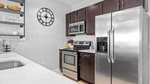 a kitchen with a stainless steel refrigerator and cabinets at Spacious 2 bd-2 ba in the Heart of Asbury Ave in Ocean City