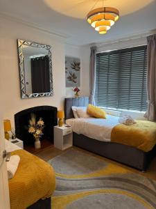 Modern 3-Bed Family Home Sleeps 6 Fast- Wi-Fi Free-Parking- Private Patio في لاوْبورو: غرفة نوم بها سريرين ومرآة +49 صورة