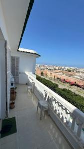 a balcony with two chairs and a view of an airport at Chambre privée au cœur de Rabat in Rabat