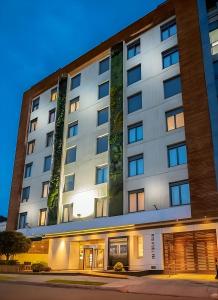 a large white building on a street at night at Biohotel Organic Suites in Bogotá