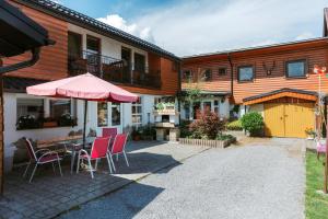 a patio with chairs and a table with an umbrella at Penzión Hubert in Zuberec