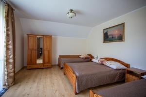 a bedroom with two beds and a cabinet at Promyk Dębiny in Debina