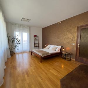 Un dormitorio con una cama y suelo de madera. en Holiday Home Junior Giacomelli, en Mati