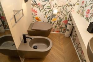 a bathroom with a toilet and a flower wallpaper at La Suite del Faso in Fasano +24 photos