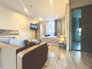 a living room with a couch and a bed in a room at La Villa l'Oiseau Bleu proche de la plage et de Deauville !!! Awards 2025 in Blonville-sur-Mer