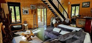 a living room with a couch and a staircase at Chalet Bois le Havre du sotrè Gérardmer Sauna panoramique jacuzzi 14 personnes et 1 bébé in Gérardmer