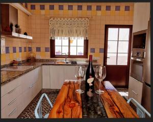 a kitchen with a wooden table with wine glasses on it at La Casona de Alba in Encinasola