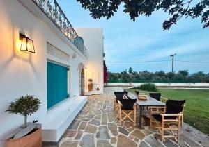 a patio with a wooden table and chairs at ᑕƳᑕᒪᗩᗪIᑕ ᐯIᒪᒪᗩ Eretria in Eretria