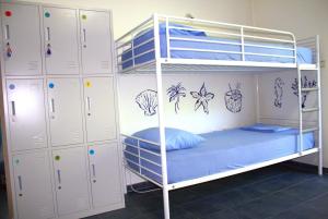 a bunk bed with blue pillows on the bottom bunk at TravelBreak in Podgorica