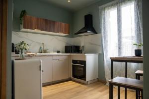a small kitchen with a refrigerator and a window at La Maison PP - Appartements in Carpentras