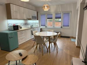 a kitchen with a table and chairs in a room at BellaRóza in Solt