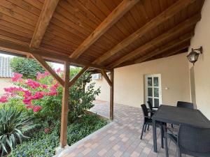 a patio with a table and chairs under a wooden ceiling at BellaRóza in Solt