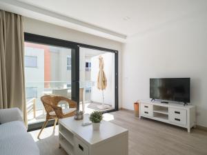 ArguineguínにあるCosta Alegre Beach Suites Arguineguinのリビングルーム(ソファ、テレビ、窓付)