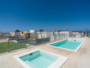 ArguineguínにあるCosta Alegre Beach Suites Arguineguinの屋上スイミングプール2つ