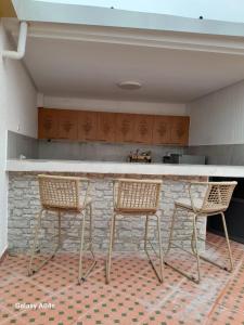 a kitchen with two chairs and a counter in a room at Central in Agadir +5 photos