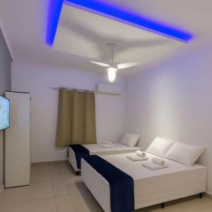 a room with two beds and a blue ceiling at Pousada encanto do sol in Búzios