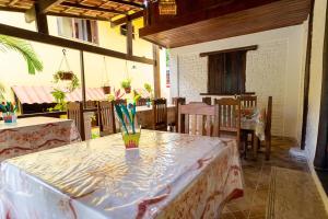 un comedor con una mesa con un jarrón. en Pousada Arraial Lua Crescente, en Arraial d'Ajuda 37 fotos más