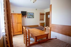a dining room with a wooden table and chairs at Promyk Dębiny in Debina