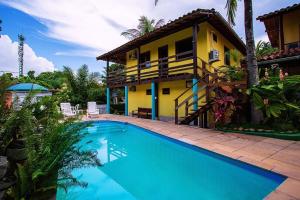 una casa con piscina delante de una casa en Pousada Arraial Lua Crescente, en Arraial d'Ajuda