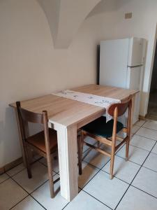 mesa de madera con 2 sillas y nevera en Lûc Dal Aur 2, en Sutrio