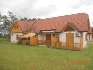 a white house with a brown roof and a yard at Apartment Nagelj in Moravske Toplice