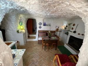 a living room with a table and a fireplace at Cueva El Madrono in Pegalajar