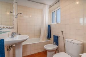 een badkamer met een wastafel, een toilet en een bad bij Casa da Lua in Aljezur +25 foto's