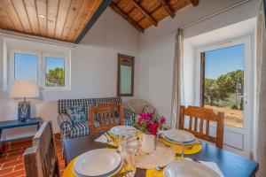 een eetkamer met een tafel met borden en bloemen erop bij Casa da Lua in Aljezur