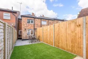 einen Hinterhof mit einem Holzzaun und Gras in der Unterkunft 93 High Street in Redbourn