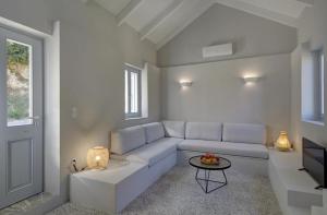 un soggiorno bianco con un divano e un tavolo di Limone Loft cottage Ithaka a Perakhórion