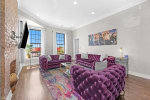 a living room with purple couches and a fireplace at Modern, Spacious 3br Apt Minutes To Downtown! in Chicago