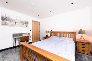 Schlafzimmer mit einem Holzbett, einem Schreibtisch und einem Schreibtisch in der Unterkunft 93 High Street in Redbourn