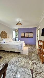 a bedroom with a large bed and a purple wall at Pousada Blue Ocean in Itacaré