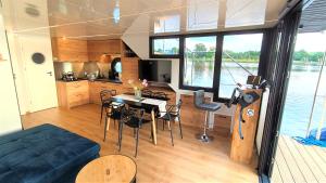 soggiorno e cucina di una barca con tavolo e sedie di Houseboat Water King apartament pływający dom na wodzie łódź Hausboot 7 os a Uraz