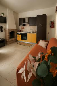 a kitchen and living room with an orange bed in a room at Grotte Relax in Grotte Santo Stefano