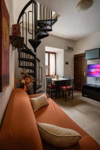 a living room with an orange couch and a spiral staircase at Grotte Relax in Grotte Santo Stefano +29 photos