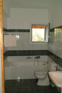 a bathroom with a tub and a toilet and a sink at Steve Apartments in Áno Garoúna