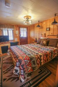 a large bed in a room with wooden walls at Chinook Winds Lodge in Dubois