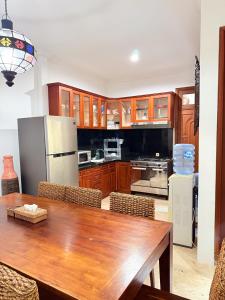 a kitchen with a wooden table and a refrigerator at Villa Mimi Mesari Kuta Bali in Kuta