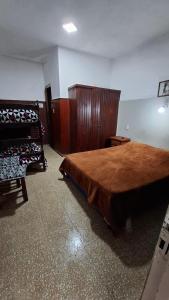 a bedroom with a large bed and wooden furniture at Hospedaje Artigas in Corrientes +3 photos